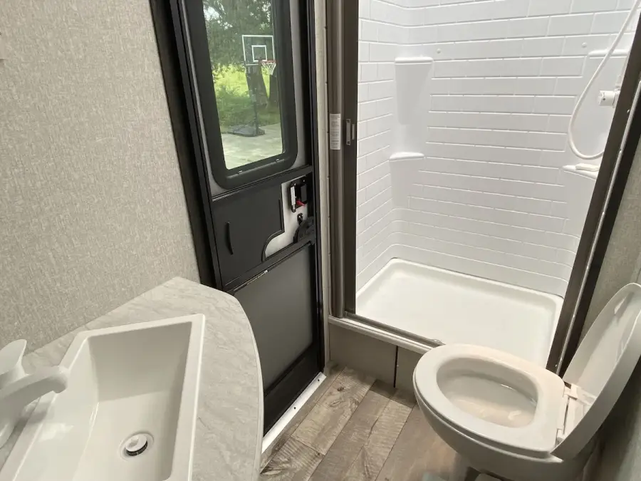 The camper bathroom has a single lav, toilet, and a stand-up shower. The camper bathroom has a single lav, toilet, and a stand-up shower.
