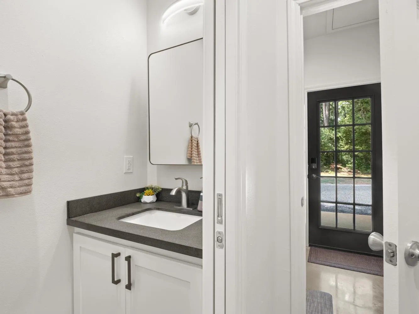 Just past the kitchen is a powder room with a sink and toilet.